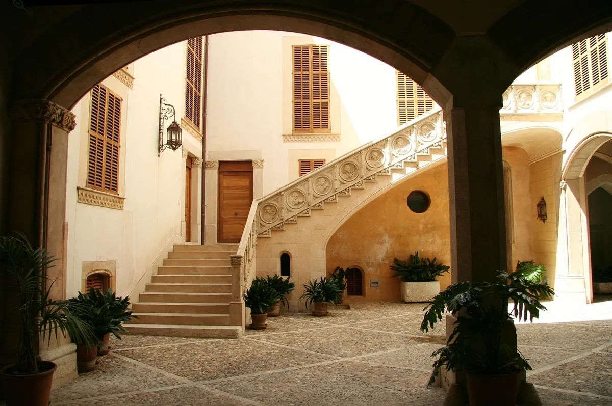 Façade et cour d'une maison ancienne rénovée montrant proportions et ouverture vers le jardin